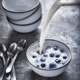 Cubertas modernas de aceiro inoxidable con cunca branca e blueberries.