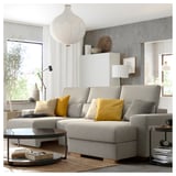 Sofá gris moderno en forma de L con almofadas amarelas, mesa de café elegante, lámpada colgante elegante nun espazo de vida minimalista.