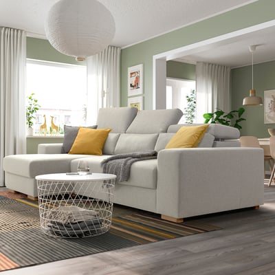 Sofá seccional gris ISTABY con almofadas amarelas no salón moderno.