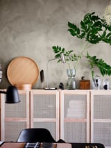 Almacenamento IVAR con portas de bambú rosa, bandexa, lámpada, planta; Estética moderna.