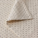 Cuberta de cama branca con costura gris escura, textura de algodón suave.