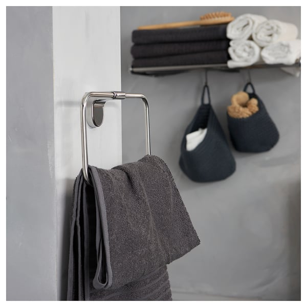 Toallas KALKGRUND con toalla gris escuro. Parede apilada con toallas brancas gris escuras e enroladas.