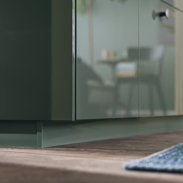 Cociña moderna con armario verde brillante e mesa de madeira.