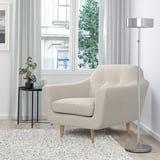 Cadeira beige KLUBBFORS por gran xanela, con lámpada e mesa lateral.