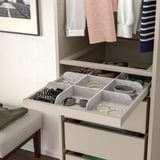 Caixón organizado con múltiples compartimentos para pequenos accesorios como cintos e xoias, tira para un fácil acceso.