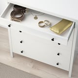 A caixa branca con 6 caixóns. O caixón aberto superior mostra cintos, xoias e bolsa. Convertible para roupa e almacenamento.