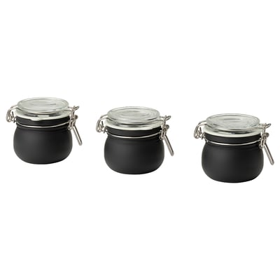 Tres frascos KORKEN negros correspondentes con tapas de vidro e abrazadeiras metálicas, dispostos nunha fila.