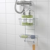 O caddy de ducha metálico contén dúas botellas verdes, colga no mesturador de ducha e inclúe dous ganchos.