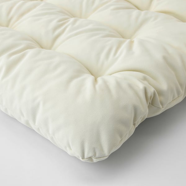 Coxín KUDDARNA en primeiro plano: superficie suave, crema, texturizada con costuras.