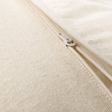 Primeiro plano de cuberta de coxín con cremalleira beige con textura tecida sutil.