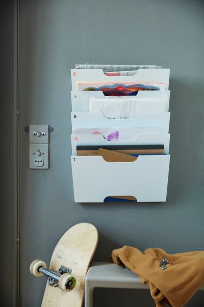 Portaficheiros KVISSLE, branco, feito de aceiro, con múltiples ranuras para arquivos ou revistas.