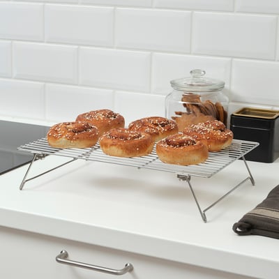 Seis produtos de forno arrefriados nun estante metálico sobre unha mesa branca.