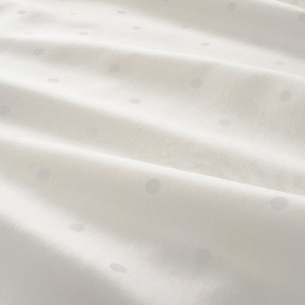 Saia de algodón branco con puntos sutís, textura suave, materiais sostibles.