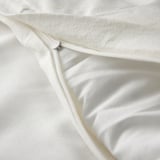 Primeiro plano de suave e branco para bebés con detalle de cremalleira.