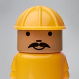 Primeiro plano da figura de lego con sombreiro amarelo, bigote detallado, cara marrón. Plástico e pintura de alta calidade.