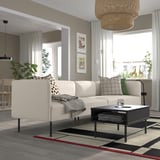 Sala de estar moderna con sofá LILLEHEM, coxíns, mesa de café, mesa lateral con planta e alfombra grande.