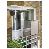 Configuración do balcón con parasol branco LILLEÖ, mesa verde, cadeiras e rede contra a parede de ladrillo.