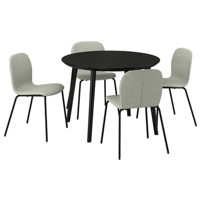 Mesa de comedor negra redonda moderna con catro cadeiras tapizadas gris claras. Deseño elegante para comer acolledor.