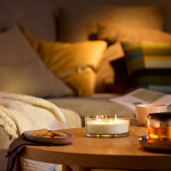 Vela LOTSFÅGEL nunha bandexa de madeira xunto á cama, pequeno reflexo de luz dourada, galletas preto.