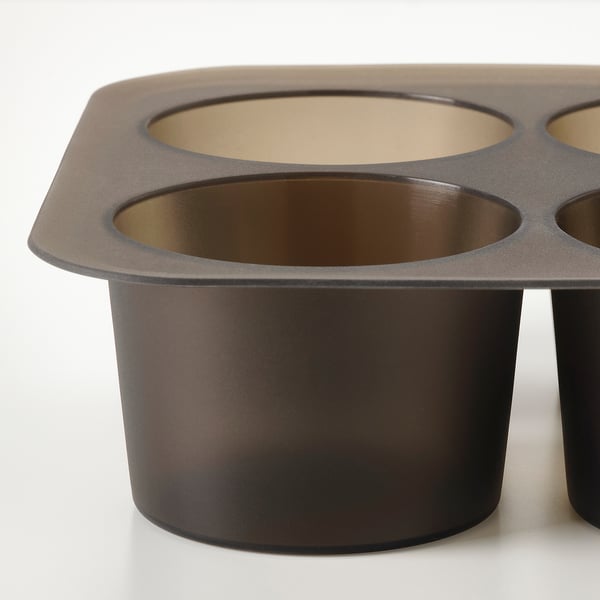 Bandexa de cubos de xeo de silicona escura con compartimentos grandes e circulares, colocados sobre unha superficie branca.