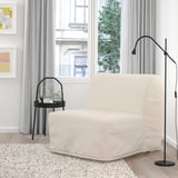 Sala de estar moderna con cadeira-cama de lycksele, lámpada, planta, alfombra, arte. Decoración minimalista.