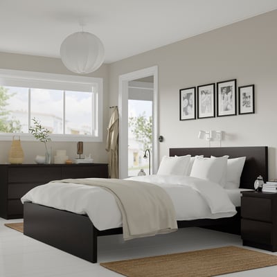 Moderno conxunto de dormitorio negro MALM incluíndo cama e 2 mesas de noite. Paredes gris claras e roupa branca. Tamaño: grande.