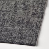 Primeiro plano de tecido gris texturizado, mostrando detalles de tecido e textura.