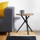 Mesa de equipo moderna MARIEDAMM con tapa de madeira clara e patas negras. Cunca gris, sofá con almofada amarela. Compacto para espazos pequenos.