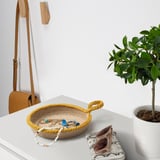 Cestas de xute sobre a mesa con xoias e plantas.