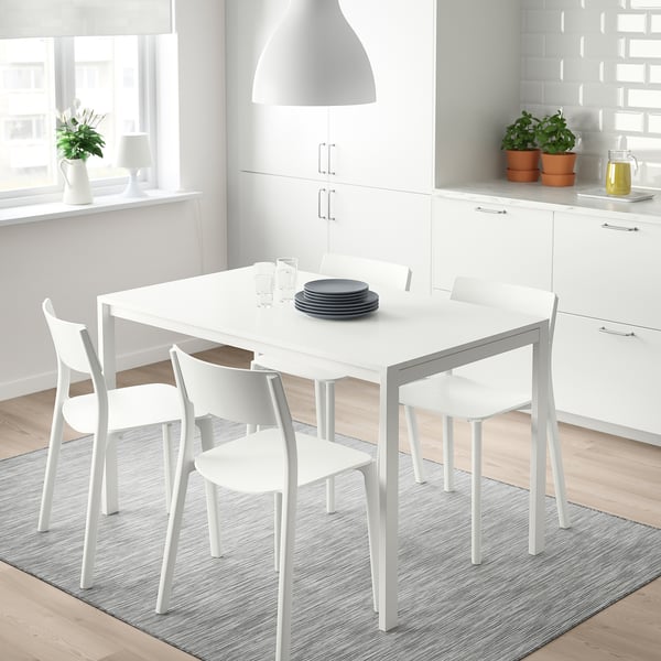 Un conxunto de comedor MELLTORP con mesa e cadeiras de marco metálico nunha cociña luminosa e moderna.