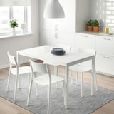 Un conxunto de comedor MELLTORP con mesa e cadeiras de marco metálico nunha cociña luminosa e moderna.