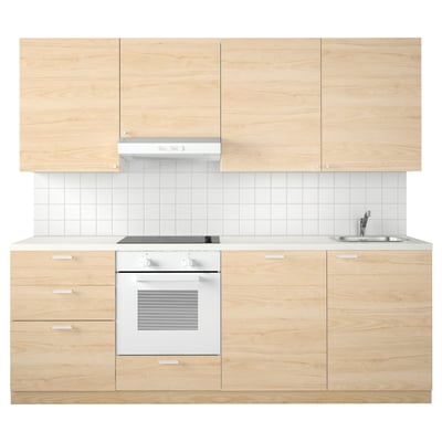 Cociña moderna de madeira lixeira con forno branco e lavabo.