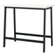 Mesa de reunión moderna de metal negro con parte superior branca, catro patas, soporte central e repousapés para asentarse ou de pé.
