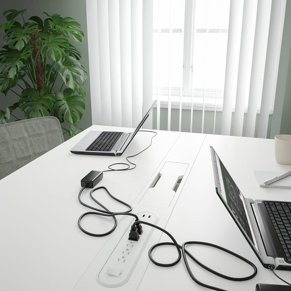 Moderna mesa de conferencias con tiras eléctricas integradas e xestión de cables, adecuada para reunións de negocios.