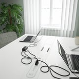 Moderna mesa de conferencias con tiras eléctricas integradas e xestión de cables, adecuada para reunións de negocios.