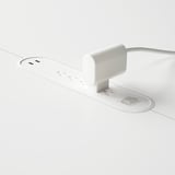 Mesa de conferencias branca con tomas de corrente incorporadas e sistema de xestión de cables.