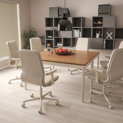 Oficina moderna con mesa de madeira clara, cadeiras beige, cunca de froitas e planta.