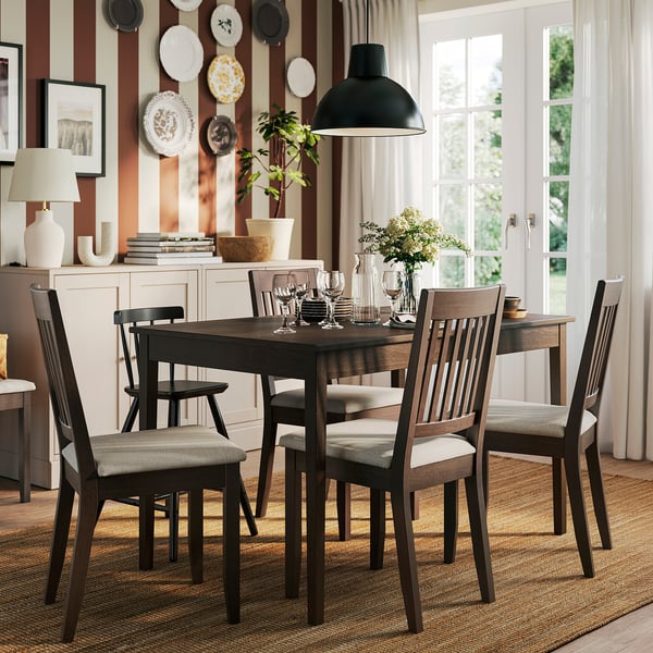 Conxunto de comedor compacto con mesa, cadeiras e sideboard nunha habitación acolledora.