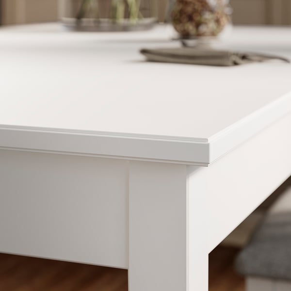 Primeiro plano do bordo elegante e branco da mesa; Acabado moderno, suave, construción robusta.
