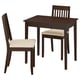 Pequeno comedor de madeira marrón escuro con dúas cadeiras e unha mesa cadrada. As cadeiras teñen coxíns beige, respaldos con lamóns.