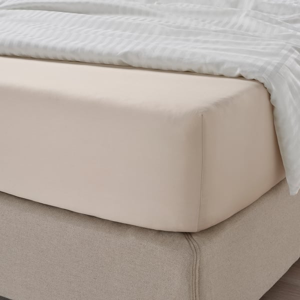 Unha cama ben feita con sabas beige, que amosa tecido de sedo para comodidade e absorción de humidade.
