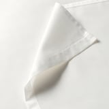 Saba de cama branca e nítida con textura suave, ben dobrada, mostrando costura fina e acabado elegante.