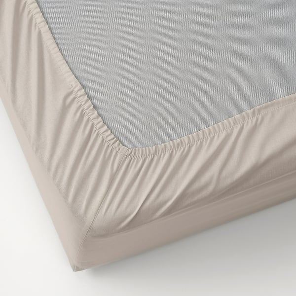 Folla beige sobre superficie branca, bordos elásticos, tecido de algodón natural.