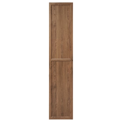Un armario de almacenamento de madeira marrón alto cunha única porta de panel, deseñado para unirse a unha libraría.