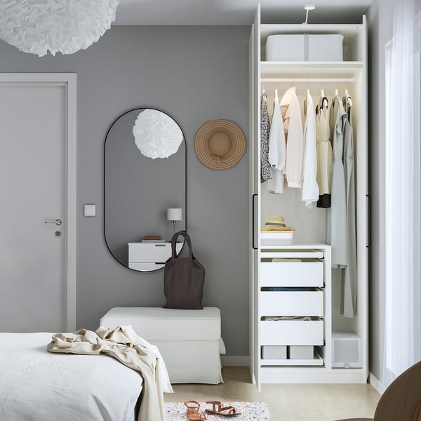 Dormitorio moderno con armario aberto que mostra roupa, espello e almacenamento.