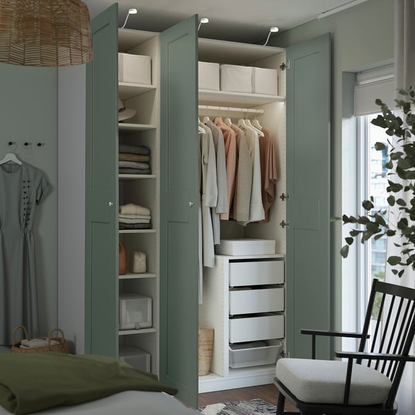 Armario pechado con acabado verde e interior branco. Estantes, caixóns e unha vara de roupa. A porta ten amortiguadores integrados para un peche lento.