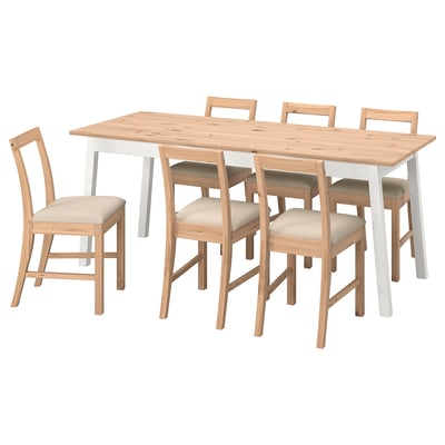 Un conxunto de comedor de madeira branca e clara, incluíndo unha mesa rectangular e catro cadeiras correspondentes con coxíns beige.