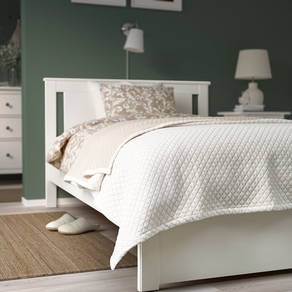 Cama moderna, paredes verdes, quilt PRAKTVIAL, mesa de noite, lámpada. Conserva concisamente a esencia do orixinal.