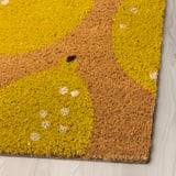 Alfombra amarela brillante con manchas brancas nun chan de madeira, material de coir de alta calidade.