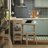 Cociña moderna con mesa e estantes RESARÖ de madeira clara.